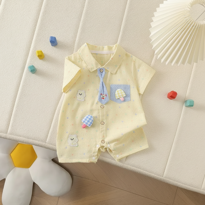 Yellow short-sleeve baby romper laid flat, showing its collar, tie, and appliqué details