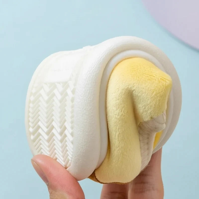 Yellow slipper bent to show its flexible white sole and chevron-patterned tread