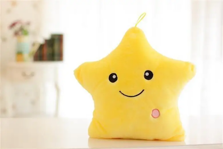 Yellow star-shaped plush pillow with a smiling face and pink button