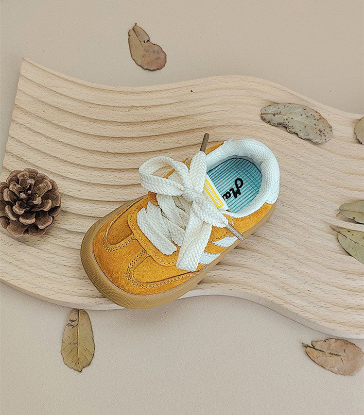Top view of a yellow sneaker showing white laces, stitched panels and a pale lining