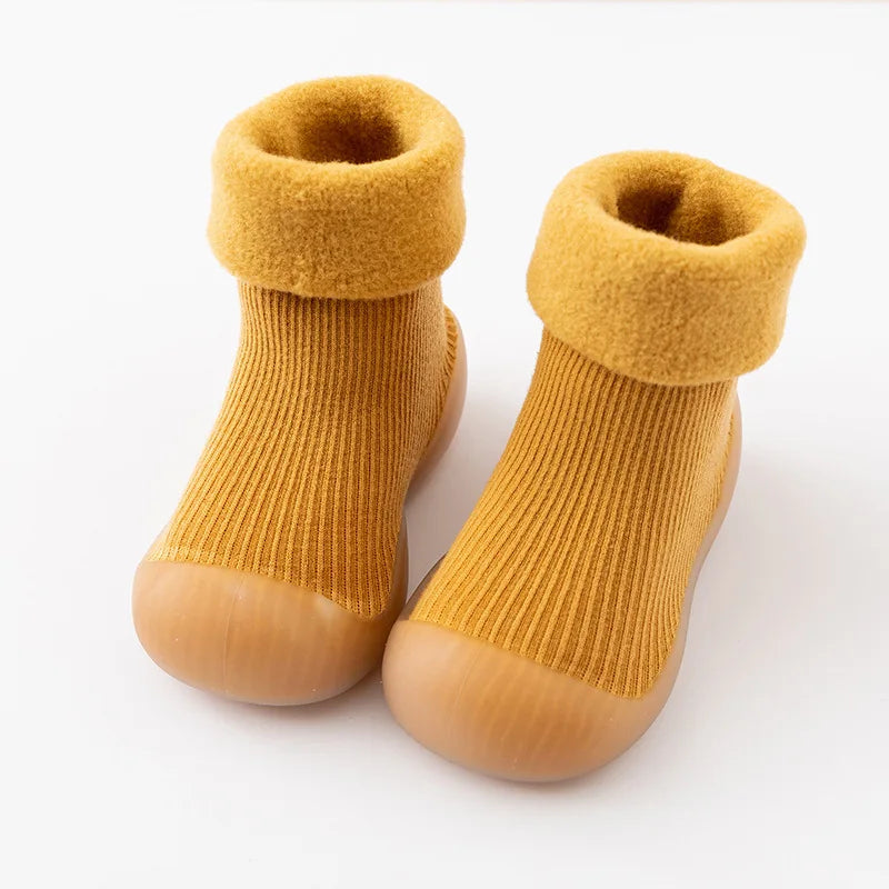 Pair of yellow sock shoes showing the ribbed uppers and thick folded cuffs.
