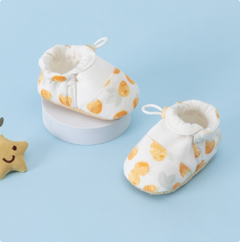 White baby shoes with yellow strawberry prints and heel pull loops