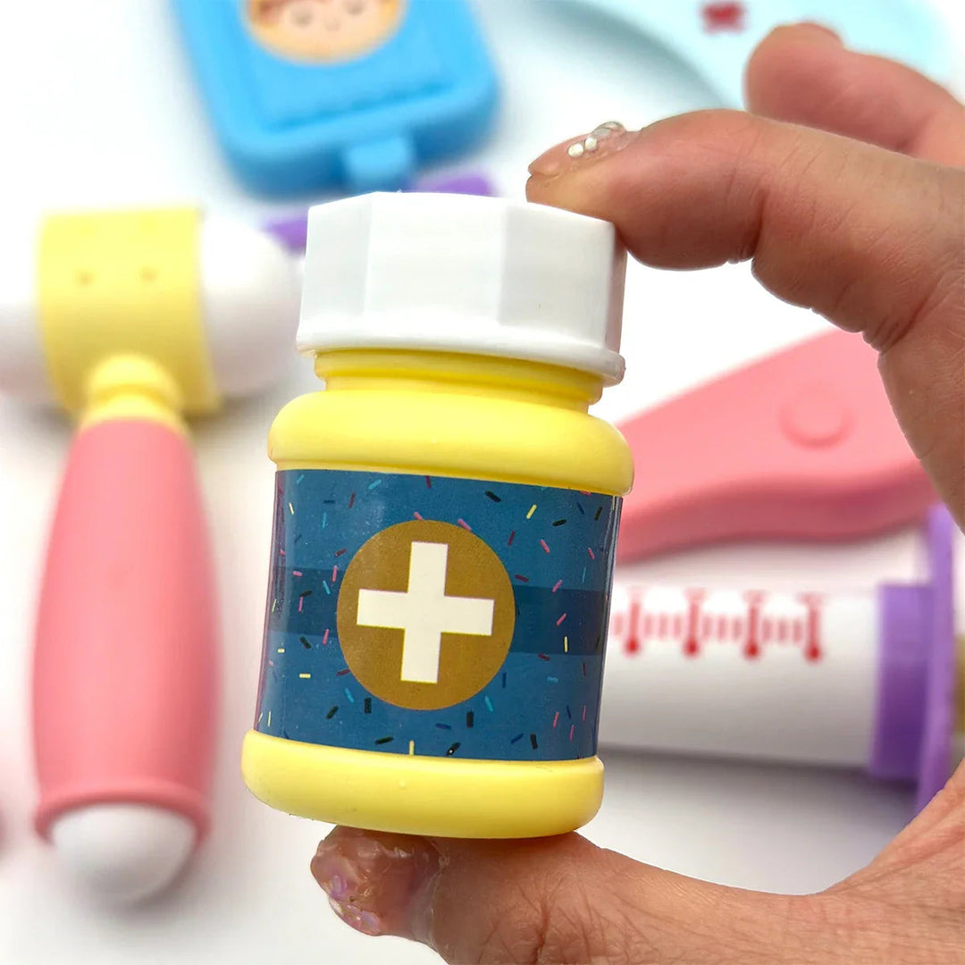 Yellow pretend medicine bottle with a white cap held above other toy doctor tools