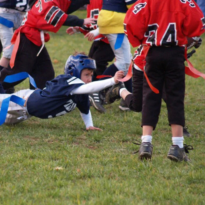 Youth football players reaching for a runner&